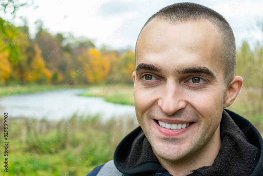 Joyful guy with a backpack smiles, man in the background of a beautiful landscape, close up, toned Joyful guy with a backpack smiles, man in the background of a beautiful landscape, close up, toned