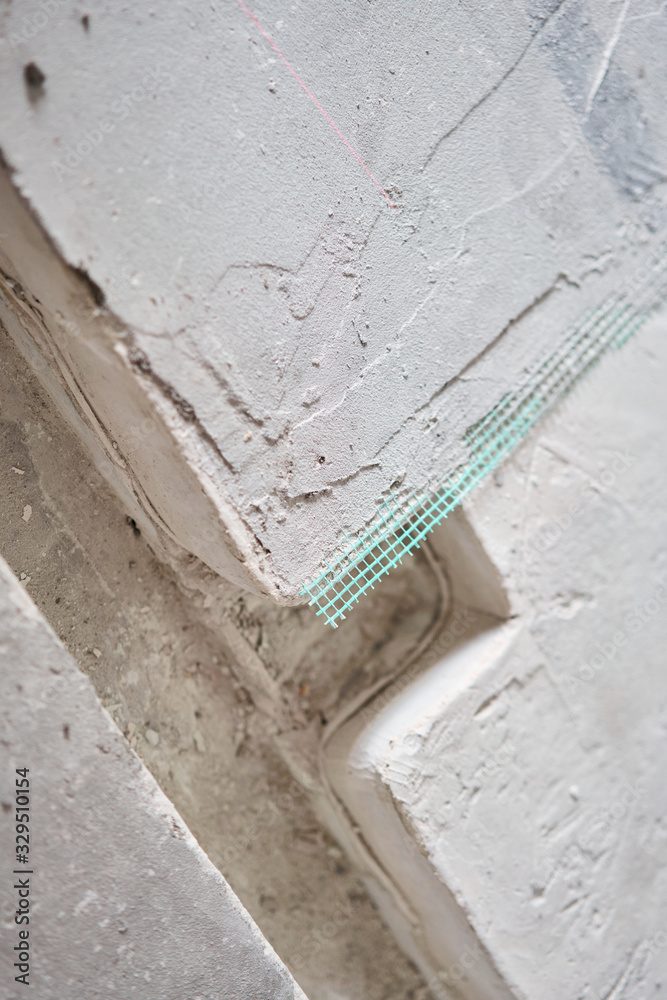 The finished floor screed is reinforced with green mesh. Repair of cracks of a bad floor screed. new building without finishing The finished floor screed is reinforced with green mesh. Repair of cracks of a bad floor screed. new building without finishing