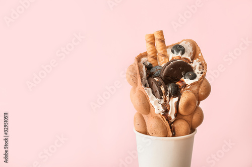 Fotografia Delicious sweet bubble waffle on color background