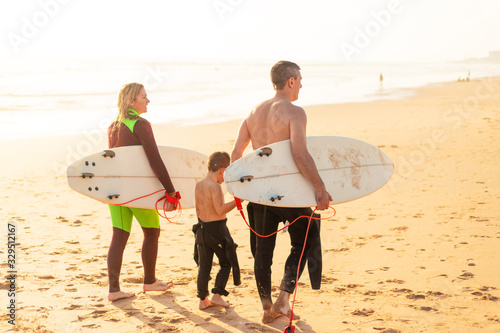 Photography Family with surfboards walking on sea coast