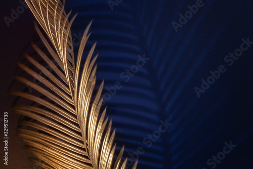 Glamor Golden tropical leaves and shadow on dark blue background, art deco st...