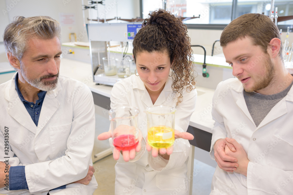 two young researchers carrying out experiments in a lab two young researchers carrying out experiments in a lab