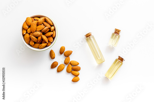 Skin care cosmetics. Almond oil in small bottles on white background top-down