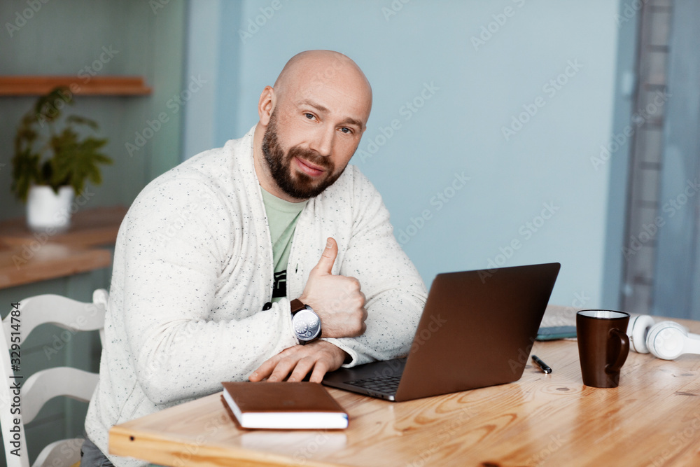 Portrait of a man working on a laptop and making the OK gesture. Portrait of a man working on a laptop and making the OK gesture.