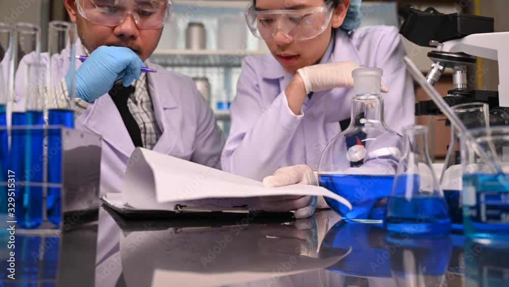 Team of Medical Research Scientists Work on a New Generation Disease Cure. They use Microscope, Test Tubes, Micropipette and Writing Down Analysis Results in Laboratory Team of Medical Research Scientists Work on a New Generation Disease Cure. They use Microscope, Test Tubes, Micropipette and Writing Down Analysis Results in Laboratory