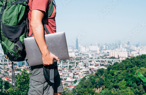 Unrecognizable digital nomad man traveling the world working photo
