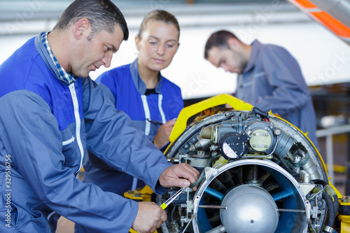 Tableau sur toile aero engineer and apprentice working on helicopter in hangar