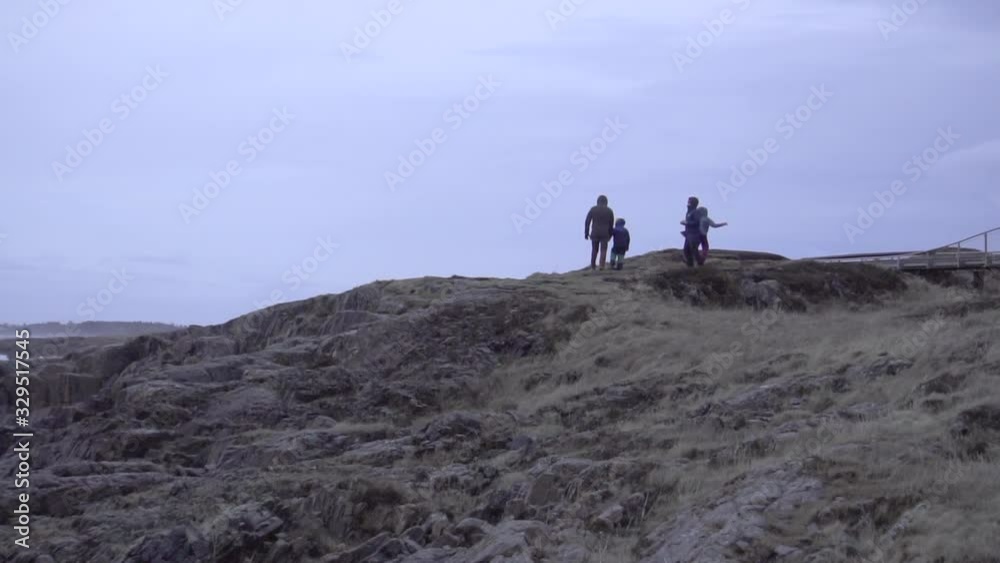 Slow motion shot: Family of four, walking on top of a hill, enjoying the scenery. Slow motion shot: Family of four, walking on top of a hill, enjoying the scenery.