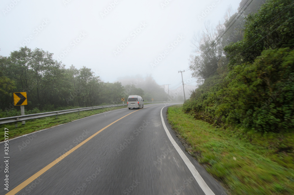 Lonely van on asphalt road in the fog