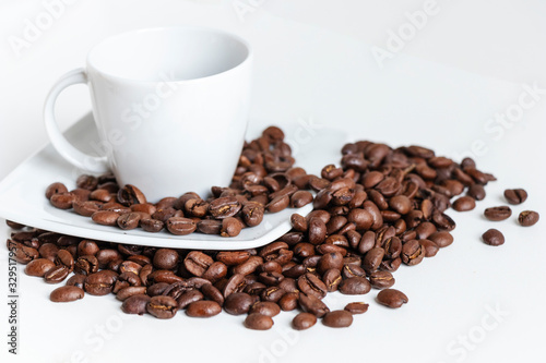 close up of white coffee cup in porcelain and grains of coffee isolated on white background with copy space.