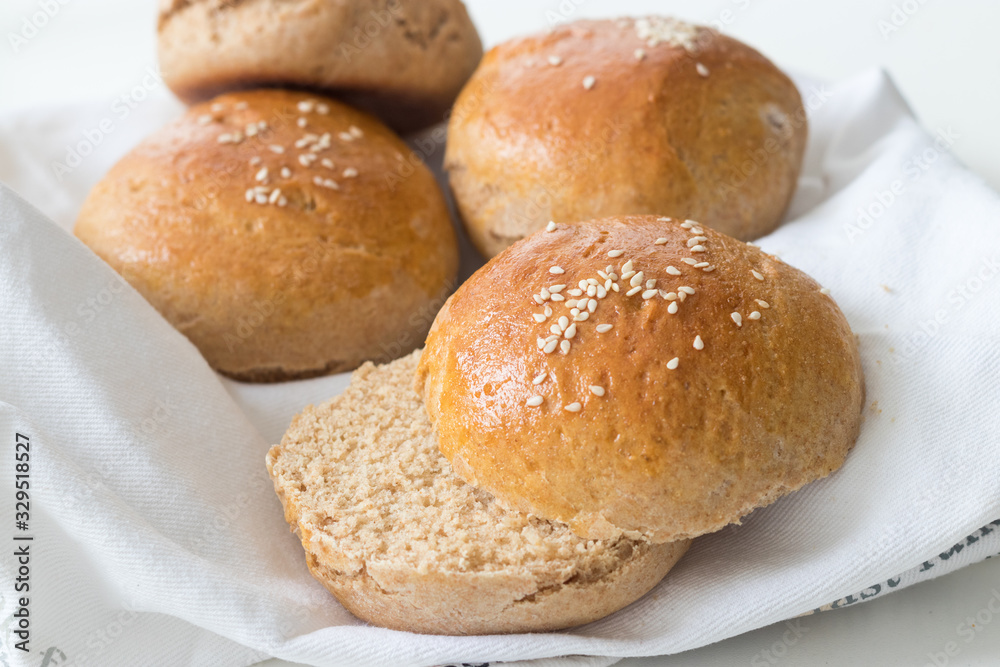 Homemade whole wheat burger buns on white table cloth