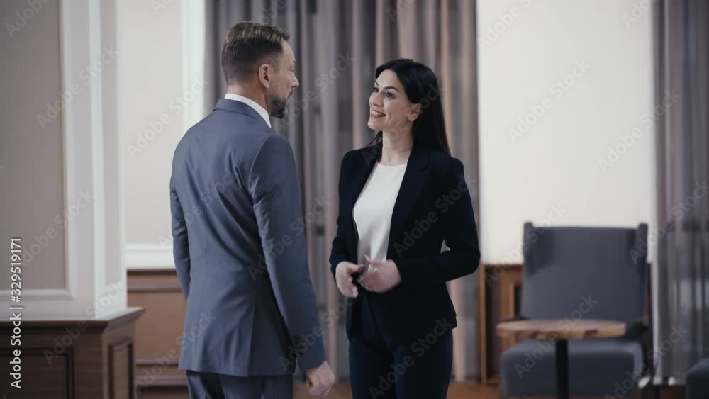 Smiling businesswoman meeting colleague in lobby of restaurant Smiling businesswoman meeting colleague in lobby of restaurant