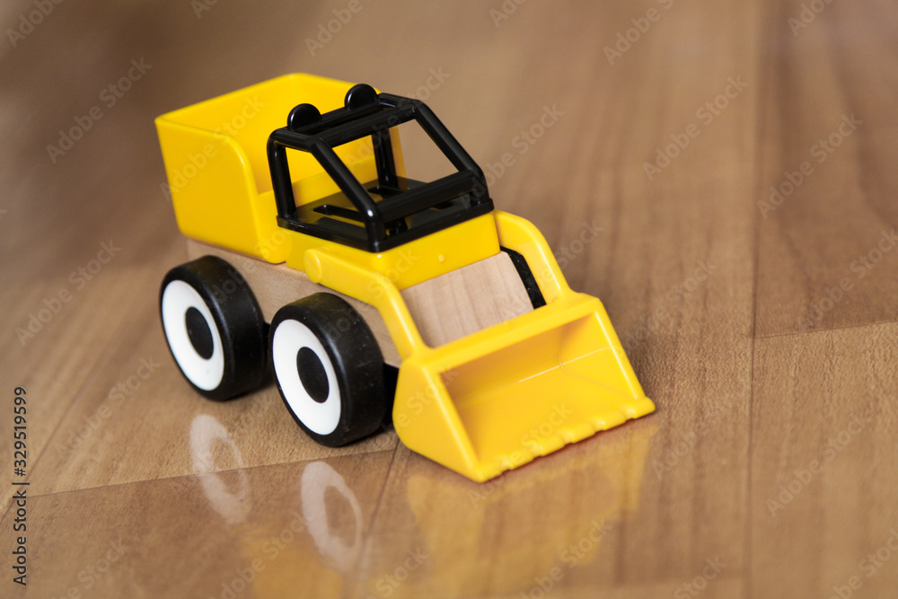 Obraz premium Yellow baby car with plastic bucket.