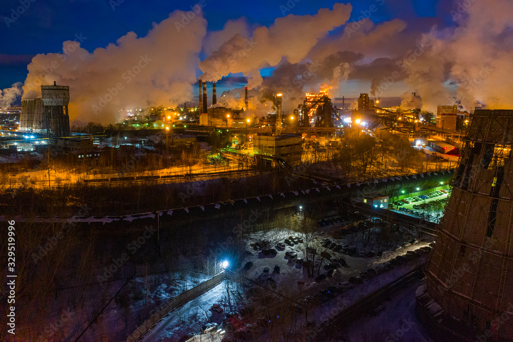 Night top view of a steel mill. Smog, smoke and flame from the chimneys