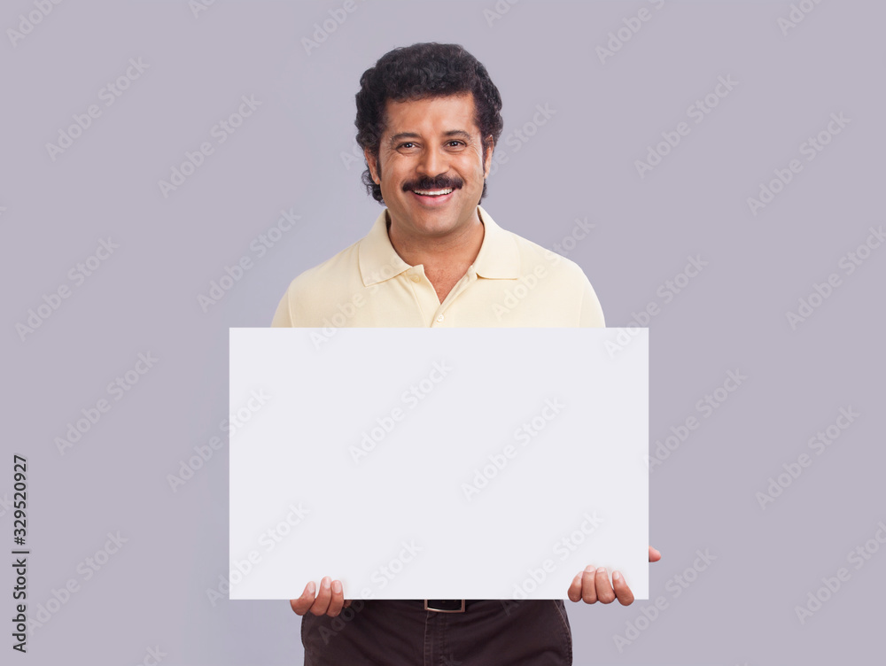 Man in happy mood holding a square shaped placard in hand. Man in happy mood holding a square shaped placard in hand.