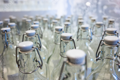 A closeup of the neck of a bottle. Group of empty bottles with plastic caps in a store on the counter.