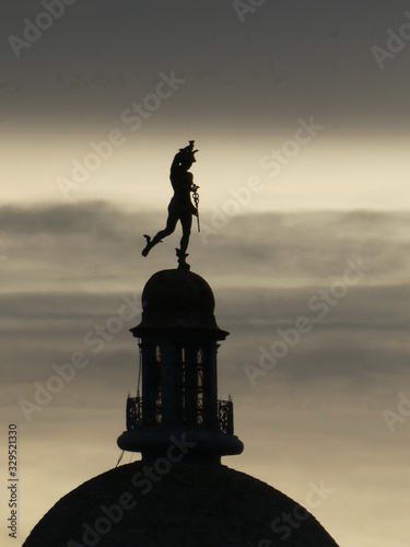 Silhouette of Statue of  Mercury/Hermes at the top of the dome of old building