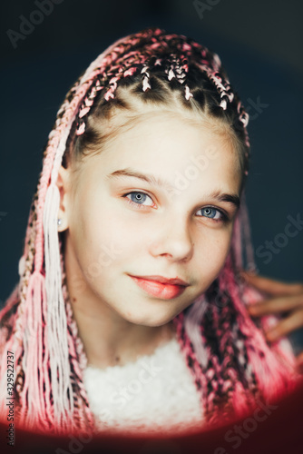 Very cute girl with braided Afro pigtails with a thread of pink color very beautiful