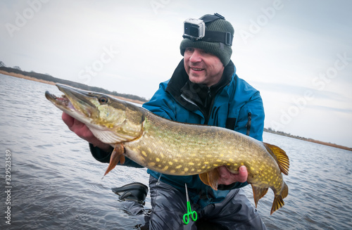 Happy angler with trophy pike from the sea