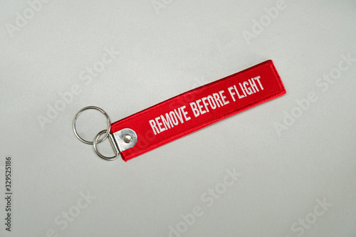 Red color remove before flight airplane safety label isolated on white close up