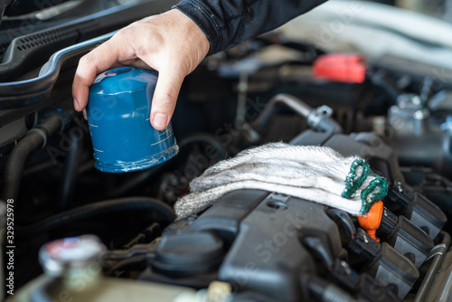 Professional mechanic man holding oil filter for repair and maintenance the car