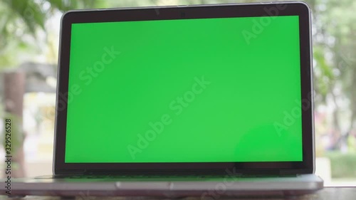 4K Green screen of laptop computer set on working space .