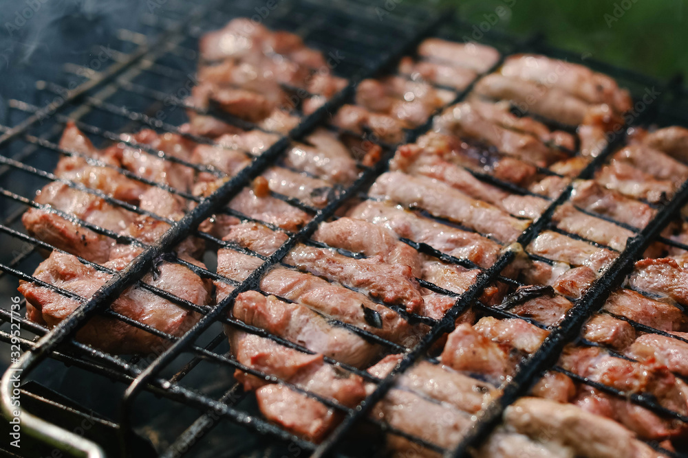 Roasting pork in a grill over a roaster. Turn the meat over on the