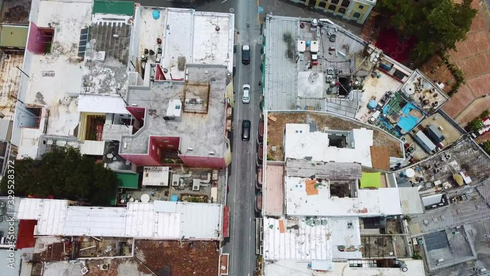 Aerial, drone shot following cars on the streets of San Juan city, sunny day, in Puerto Rico, USA