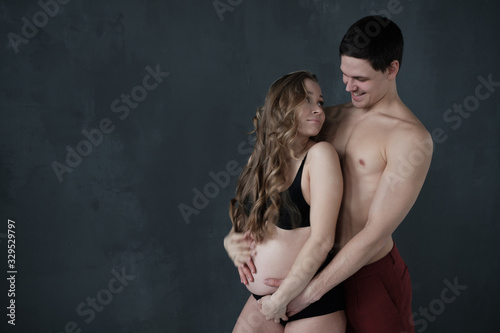 Man holding belly of his pregnant wife.