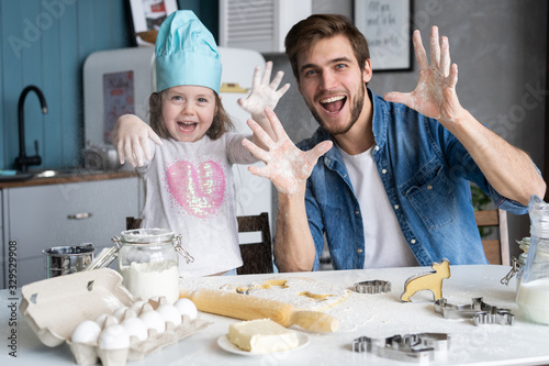 Happy father and daughter having fun while cooking together.