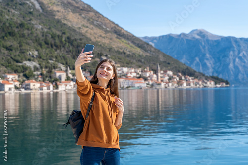 Happy woman traveler take photo selfie by camera in Montenegro near Perast city