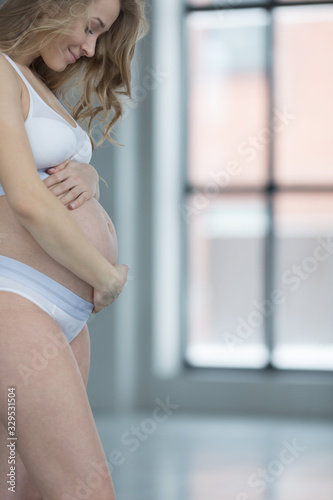 Beautiful pregnant girl in an empty room.