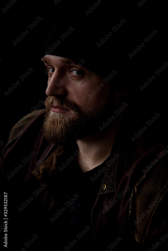 a mysterious portrait of a man with a beard on a black background with a small amount of light a mysterious portrait of a man with a beard on a black background with a small amount of light