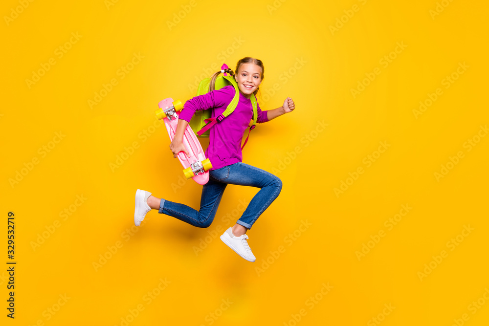 Full length body size view of her she nice attractive glad purposeful cheerful cheery girl jumping running carrying longboard having fun isolated on bright vivid shine vibrant yellow color background