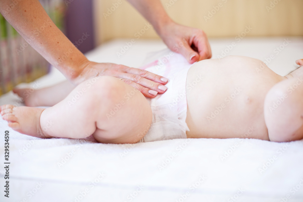 mother changing the diaper of her baby at home mother changing the diaper of her baby at home