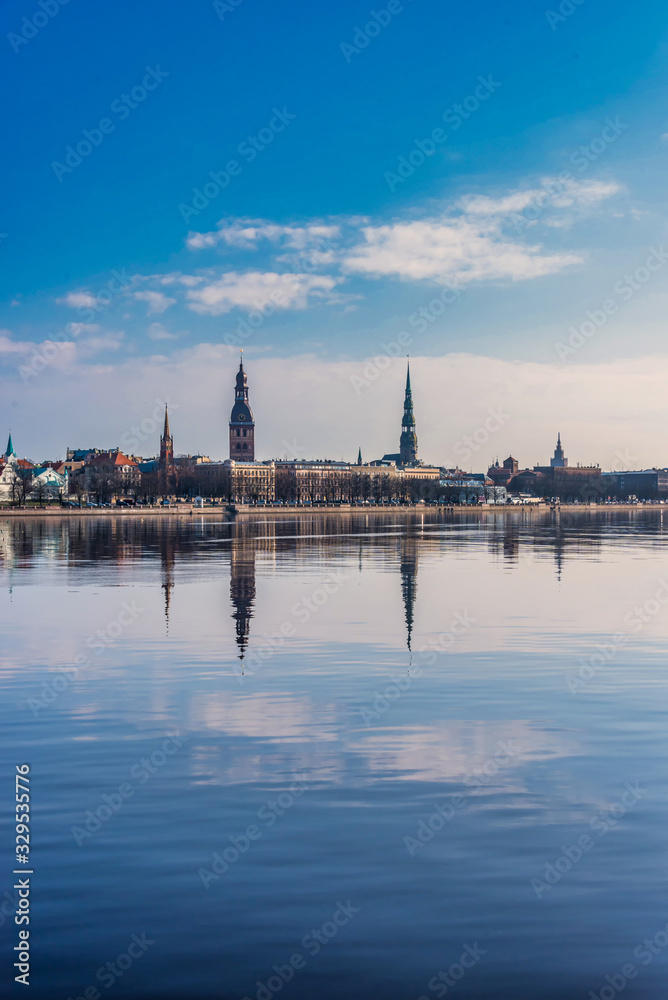 Fototapeta premium Cityscape of Riga Latvia with Reflections on a Quiet Still River