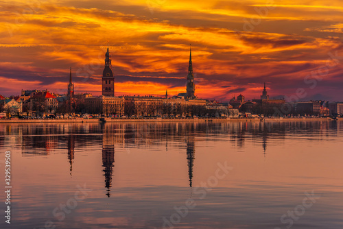 Cityscape of Riga Latvia with Reflections on a Quiet Still River at Sunset