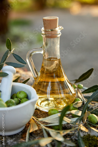 olive oil in the bottle and branch of green olives
