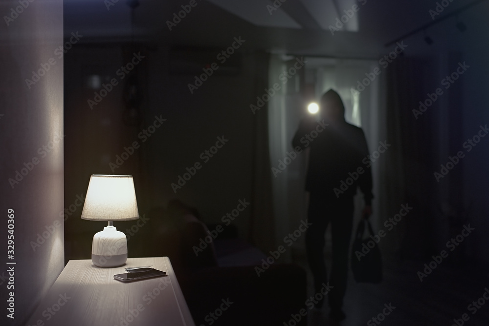 Burglar inside of a house with flashlight                