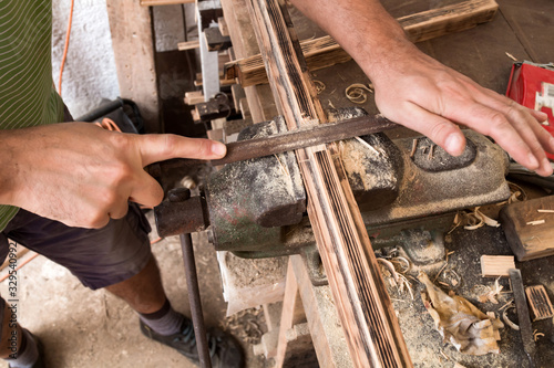 Male carpenter working on old wood in a retro vintage workshop. © astrosystem