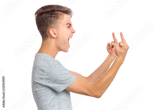 Obraz na plátně Angry teen boy showing middle finger - side view, isolated on white background