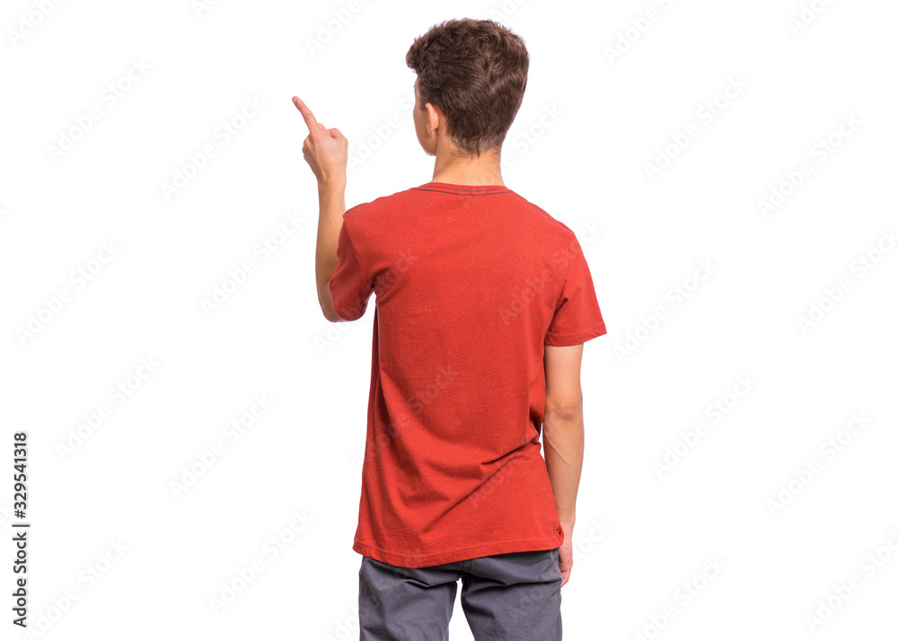 Back view. Teen boy pointing finger away at copyspace, isolated on white background. Teenager in red t-shirt pointing finger at something - rear view. Back view. Teen boy pointing finger away at copyspace, isolated on white background. Teenager in red t-shirt pointing finger at something - rear view.