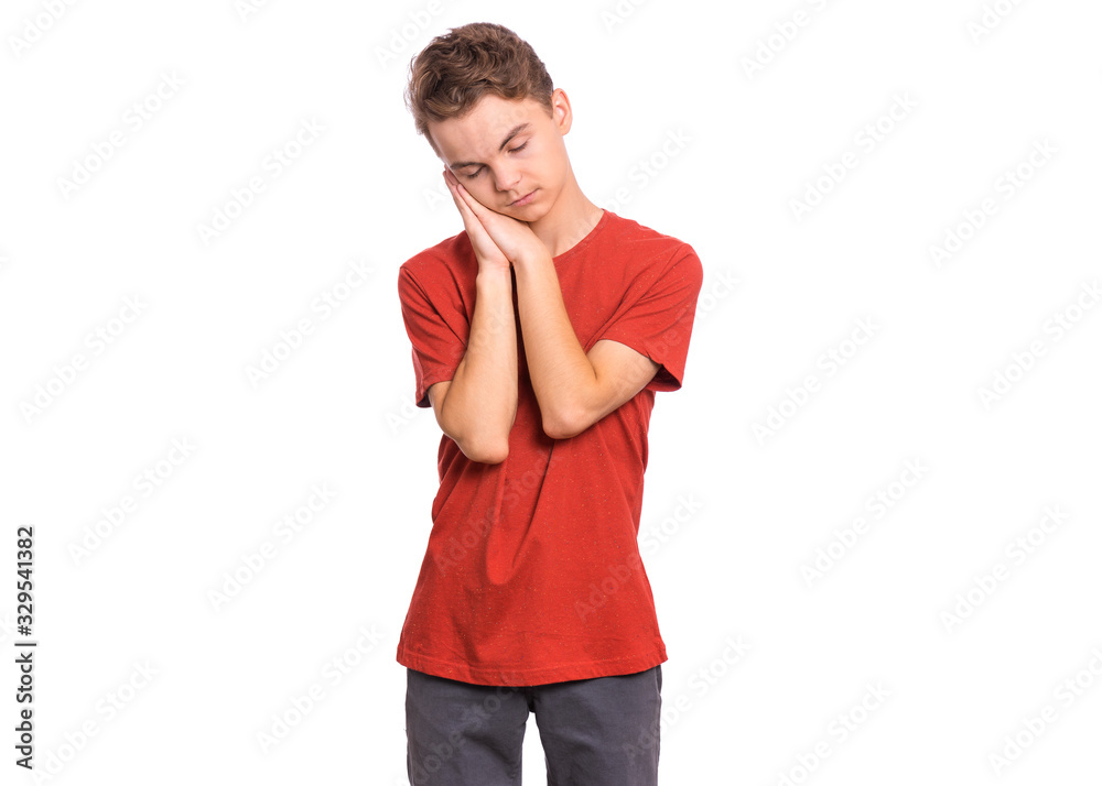 Portrait of teen boy sleeping tired or dreaming posing with hands together while smiling with closed eyes. Cute young caucasian teenager isolated on white background. Happy child.