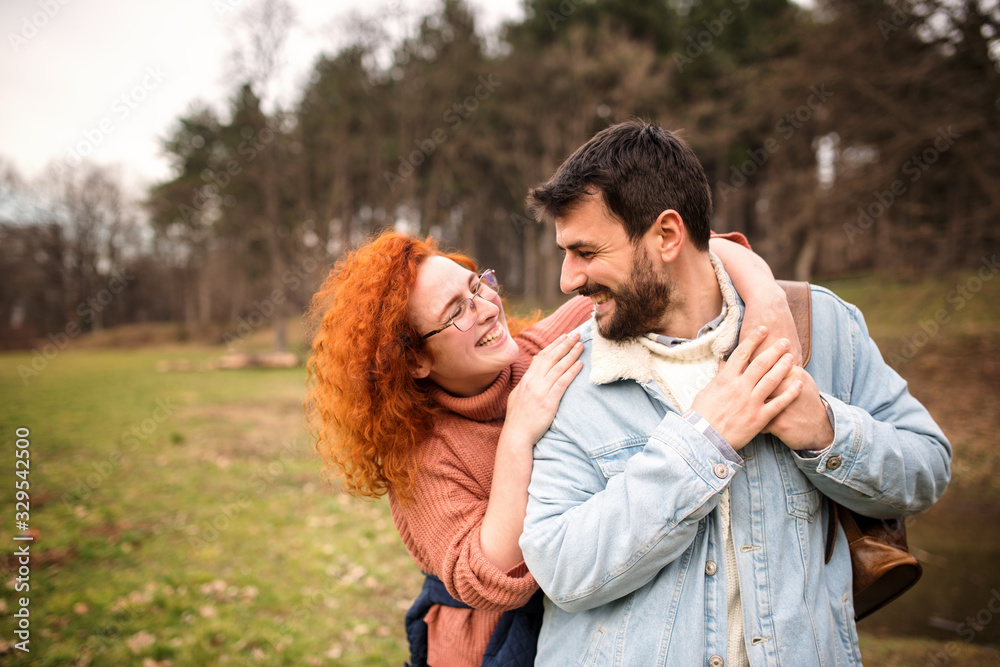 couple on a field trip. a joint journey of two young people. Girl with orange hair is having fun in the woods with a guy who has a beard couple on a field trip. a joint journey of two young people. Girl with orange hair is having fun in the woods with a guy who has a beard