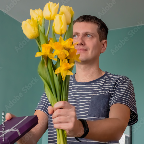 Man with a gift box and yellow flowers - daffodils and tulips