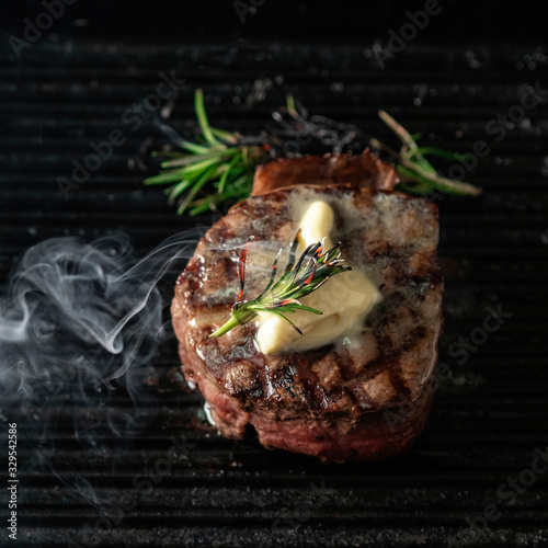 A steaming beef tenderloin steak is grilled in a grill pan with the text copy space. The concept of the recipe , filet Mignon photo