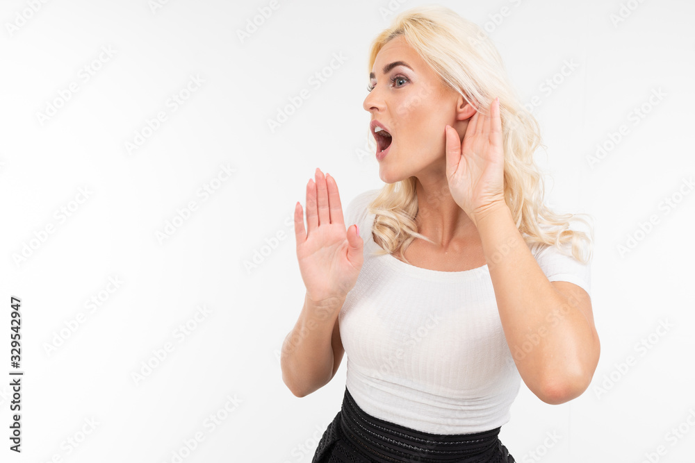 girl asks to be louder while holding her hand by the ear on a white studio background girl asks to be louder while holding her hand by the ear on a white studio background