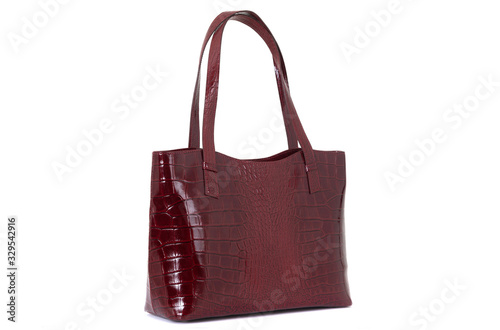 expensive red female leather bag on a handle isolated on a white background
