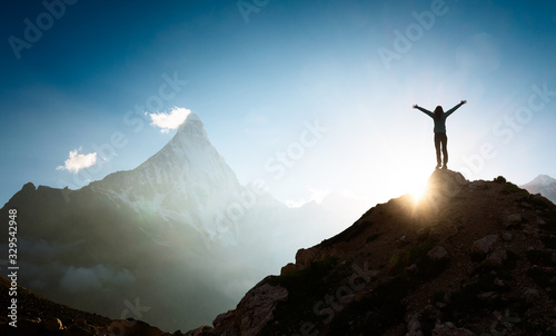 Woman with arms outstretched enjoying the sunrise in the mountains photo
