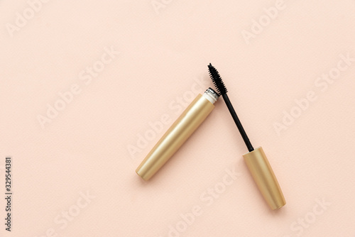 Open mascara with brush on pink background. Copy space. Flat lay. Top view. Skin care or morning routine concept